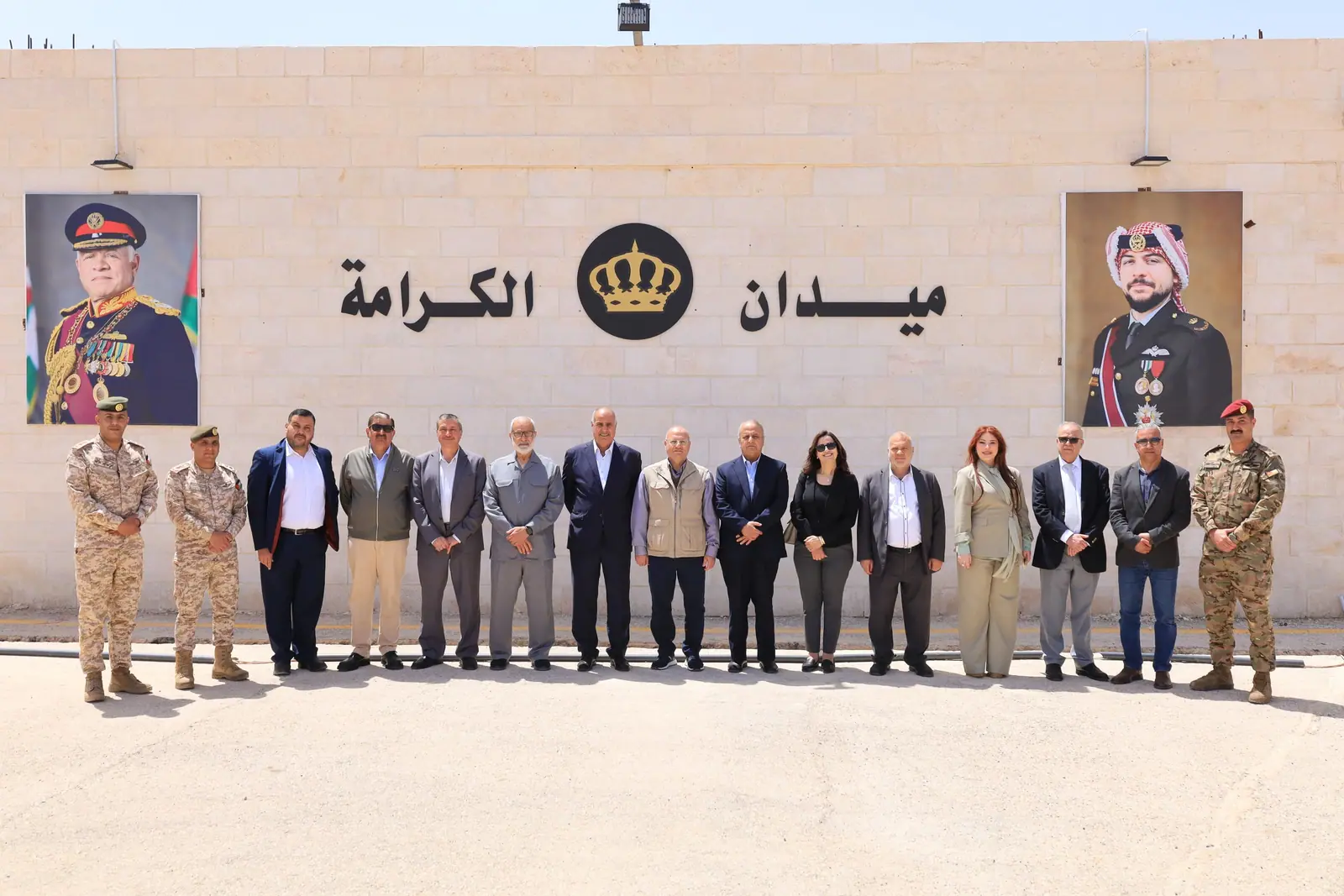 Delegation at Maydan Al-Karama with the national leadership portraits